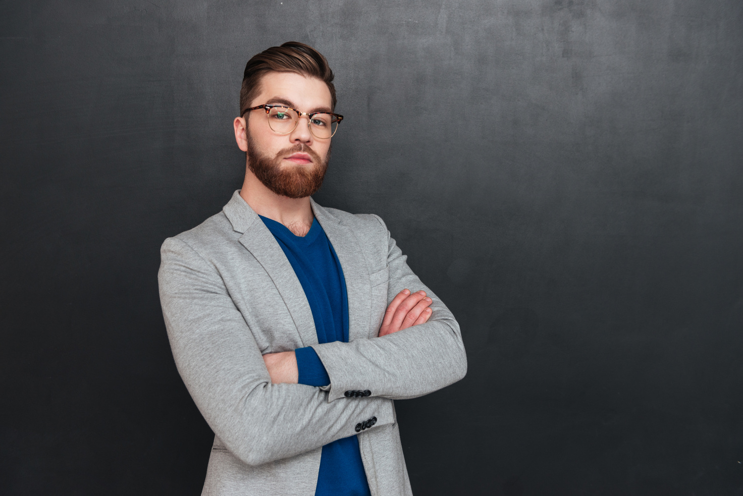 Confident Bearded Young Businessman Standing with Arms Crossed